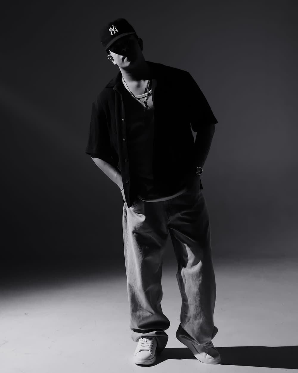 Sebastián standing in a studio, black and white, lit from the side